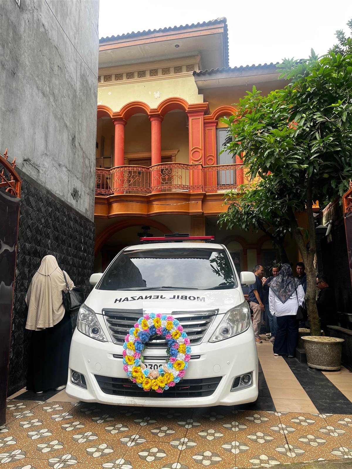 Mobil jenazah dengan karangan bunga di atas